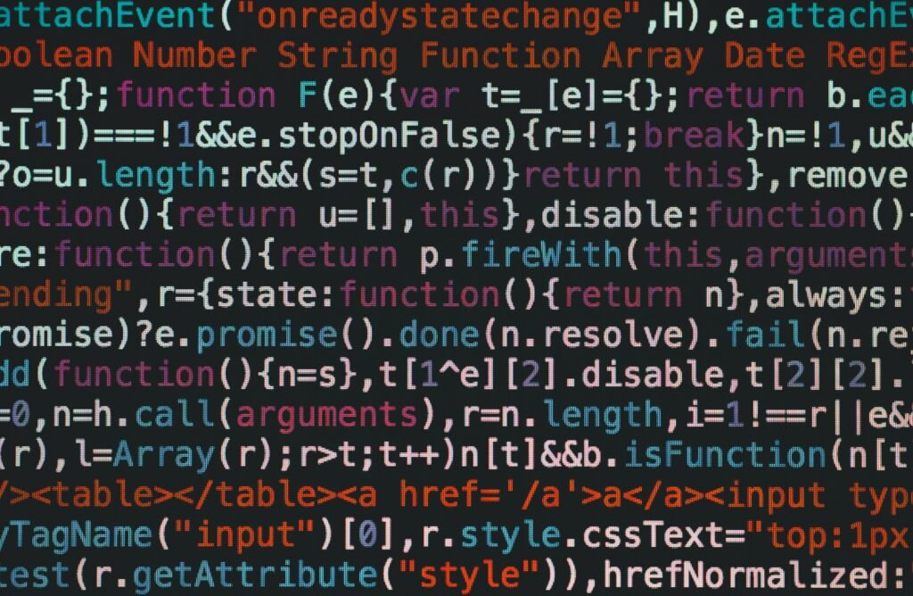pexels-photo-965345-965345 Close-up of colorful coding text on a dark computer screen, representing software development.