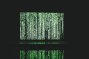 Abstract depiction of green matrix code on a computer monitor.